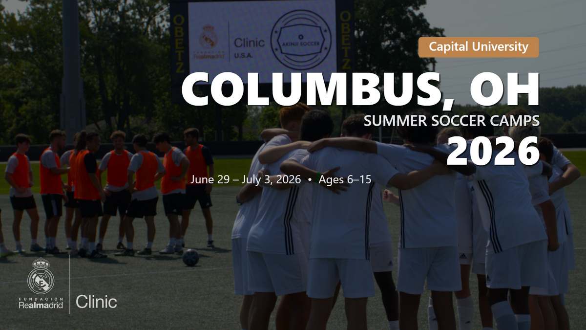 Kids in Real Madrid uniforms huddling with coaches during a 2026 summer soccer camp in Columbus, OH at Capital University.